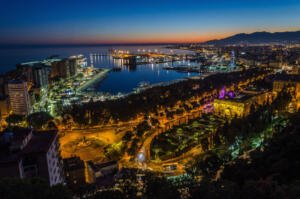malaga city at night with buildings overlooking the sea