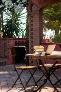 Person working on a laptop outdoors at a rustic table, representing the digital nomad lifestyle in Spain