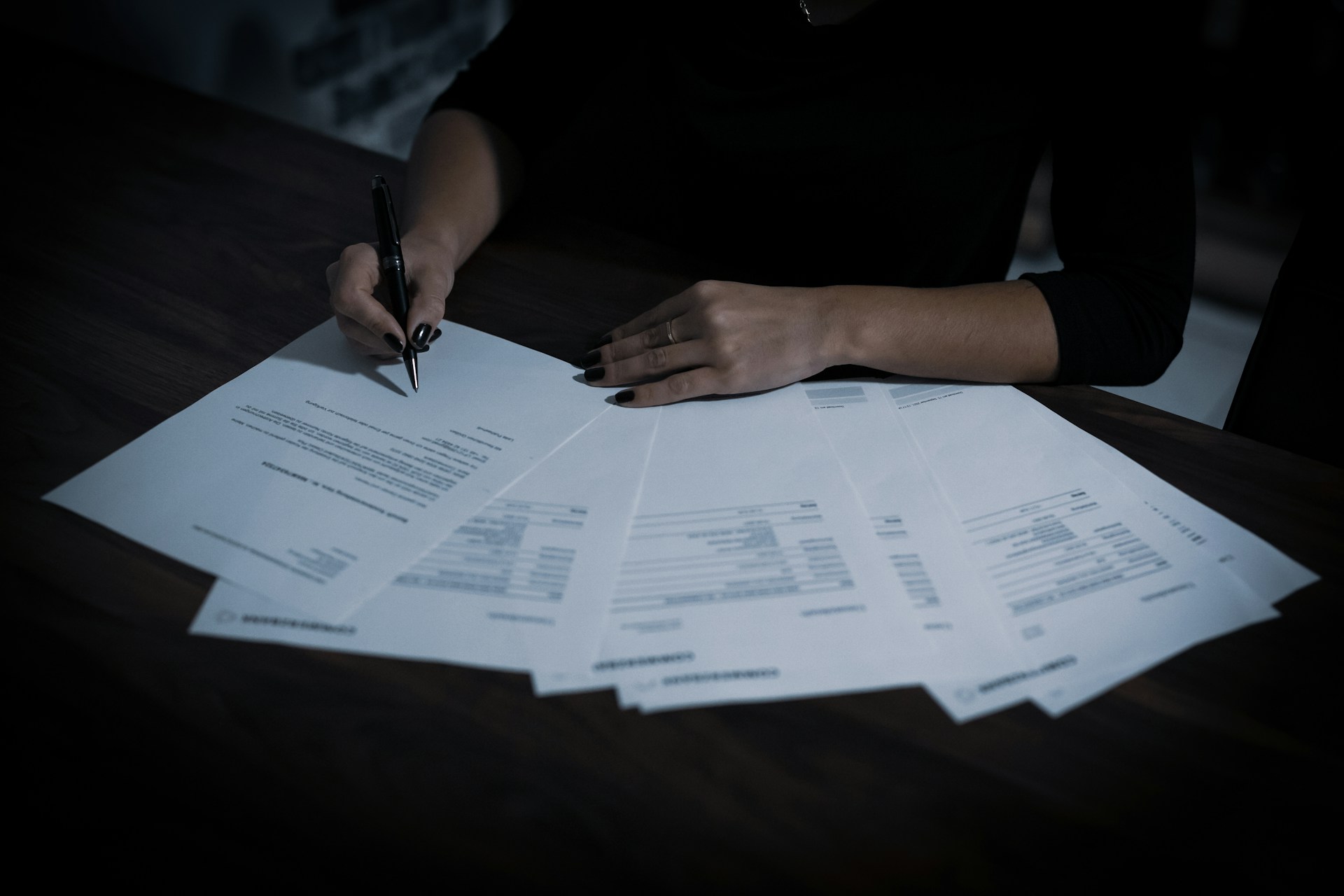 Woman signing a legal document at a desk — Power of Attorney for buying property in Spain as a British buyer
