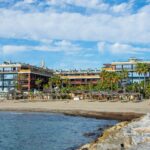 Coastal resort apartments on a sandy Costa del Sol beach, showing the type of property British buyers let as holiday rentals in Spain