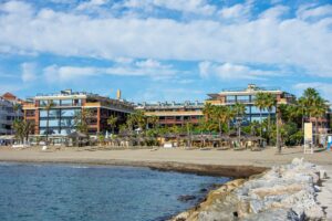 Coastal resort apartments on a sandy Costa del Sol beach, showing the type of property British buyers let as holiday rentals in Spain