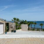 Luxury coastal apartment building with palm trees and blue Mediterranean ocean on the Costa del Sol near San Pedro de Alcantara
