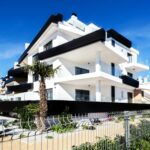 Property keys and a Spanish apartment building - how much deposit to buy property in Spain