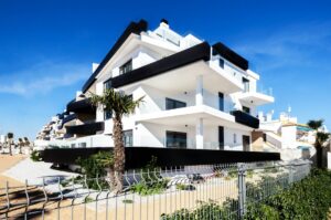 Property keys and a Spanish apartment building - how much deposit to buy property in Spain