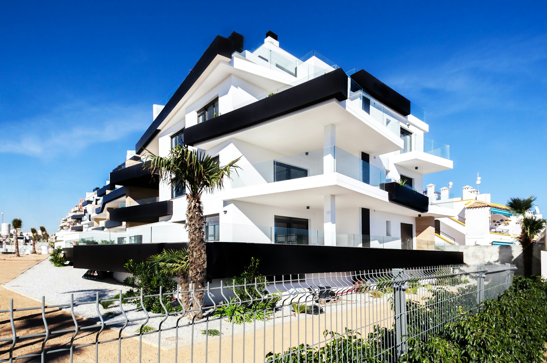 Property keys and a Spanish apartment building - how much deposit to buy property in Spain