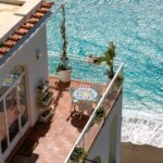 A tiled terrace with table and chairs overlooking the blue Mediterranean sea - Costa del Sol property management