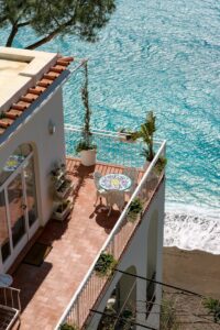 A tiled terrace with table and chairs overlooking the blue Mediterranean sea - Costa del Sol property management
