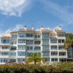 Modern white apartment building with balconies and palm trees on the Costa del Sol, Spain