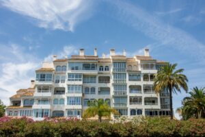 Modern white apartment building with balconies and palm trees on the Costa del Sol, Spain