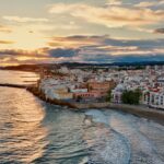 Aerial view of a Spanish coastal town at sunset with sandy beaches and the Mediterranean Sea