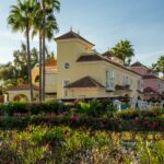 Yellow Mediterranean villa with palm trees and vibrant flowers on the Costa del Sol, Spain