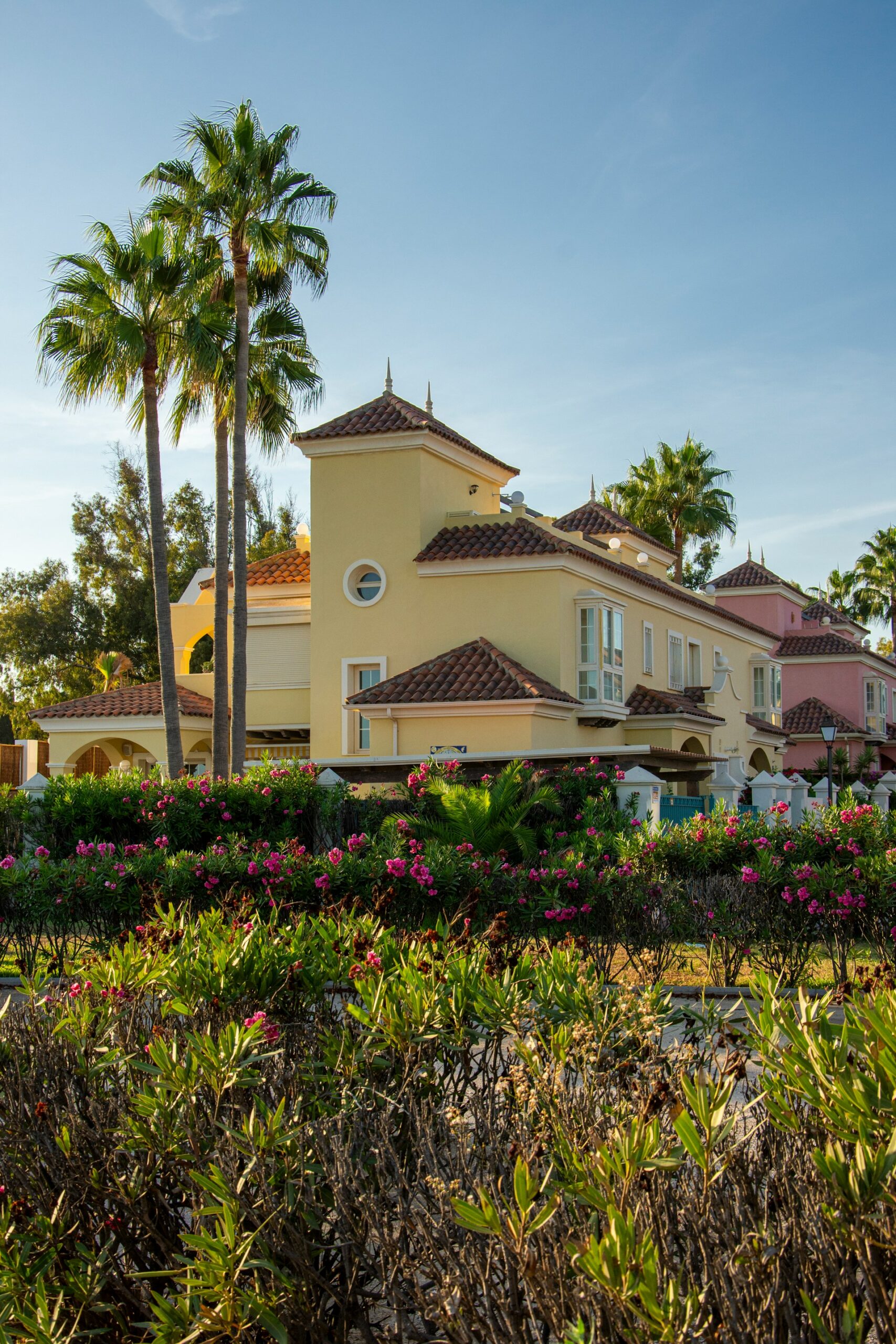 Yellow Mediterranean villa with palm trees and vibrant flowers on the Costa del Sol, Spain